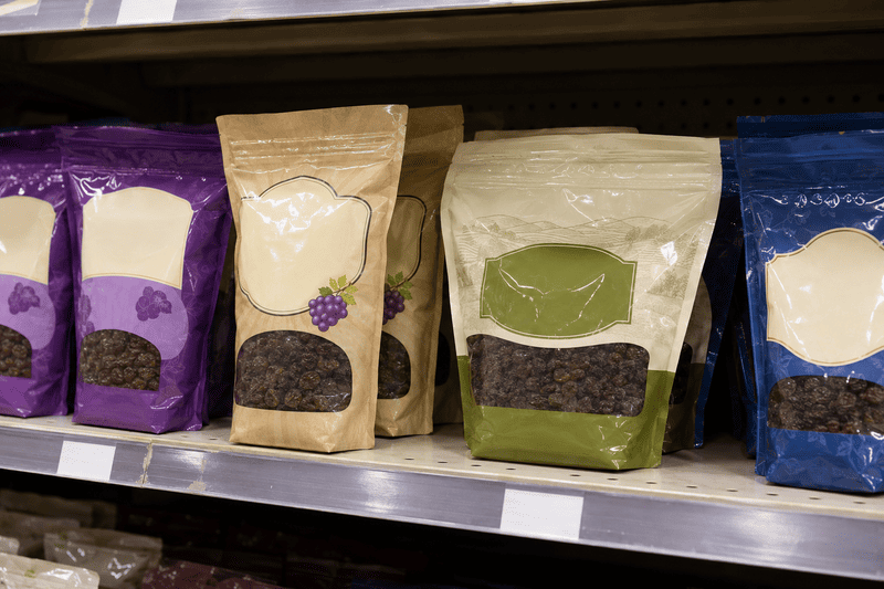 An assortment of private label raisin packages on a supermarket shelf